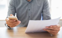 Businessman reading document and texting message