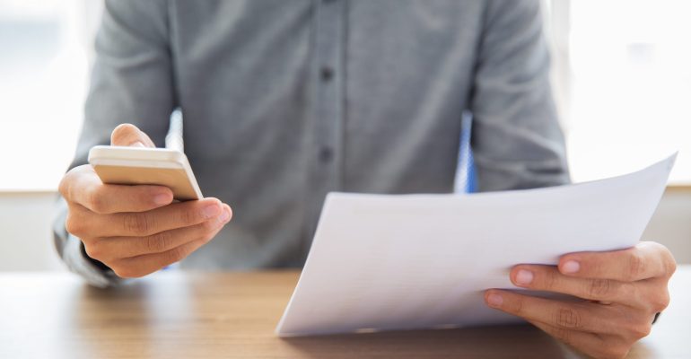 Businessman reading document and texting message